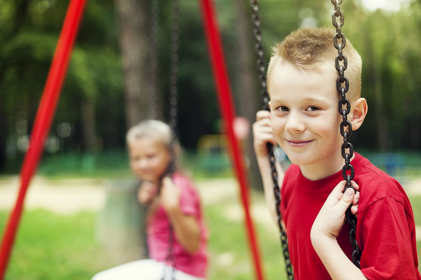 Two children swinging side by side outdoors